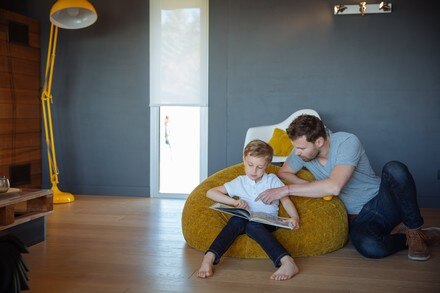 Smarter Innensonnenschutz: Vater mit Sohn beim Lesen